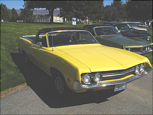 Yellow Ford Ranchero car-pickup, front three-quarter, at an outdoor car show