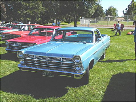1967 Ford Ranchero - A light blue 1967 Ford Ranchero is parked on a grassy field next to other vehicles.