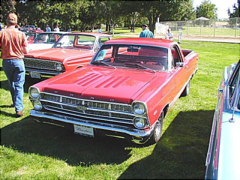 1967 Ford Ranchero - A red 1967 Ford Ranchero is displayed at an outdoor event with other vehicles.