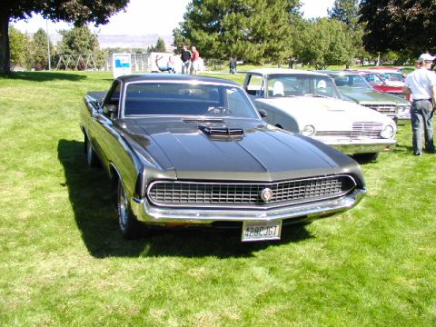 1967 Ford Ranchero - This 1970 Ford Ranchero features a distinctive hood scoop and prominent front grille, seen at an outdoor car show.