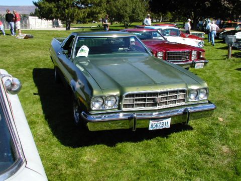 1967 Ford Ranchero - A green 1977 Ford Ranchero is parked on a grassy field with other vehicles in the background.