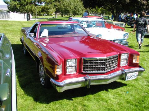1967 Ford Ranchero - A red 1977 Ford Ranchero is displayed at an outdoor car show with other vehicles in the background.