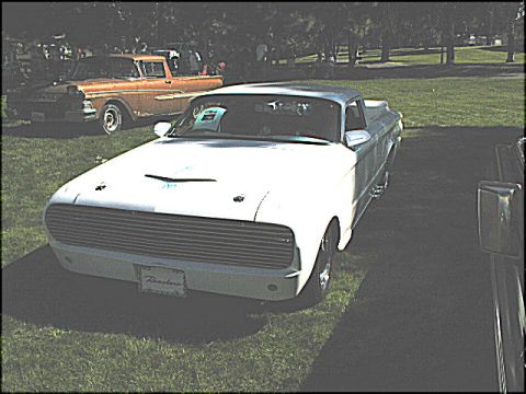 1967 Ford Ranchero - A white 1967 Ford Ranchero is displayed with a custom front end and a prominent grille.