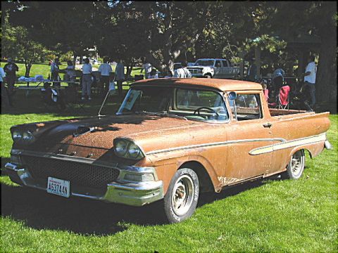 1967 Ford Ranchero - A weathered 1957 Ford Fairlane Ranchero is displayed at an outdoor gathering, with other vehicles and attendees visible.
