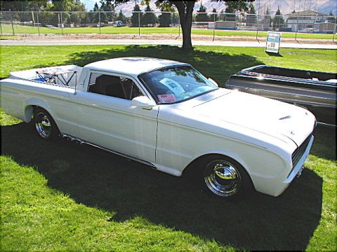 1967 Ford Ranchero - A white 1967 Ford Ranchero pickup truck is displayed on a grassy field with a blue sky overhead.
