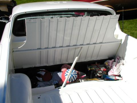 1967 Ford Ranchero - The bed of a white 1967 Ford Ranchero pickup truck is filled with various items, including a cooler and blankets.