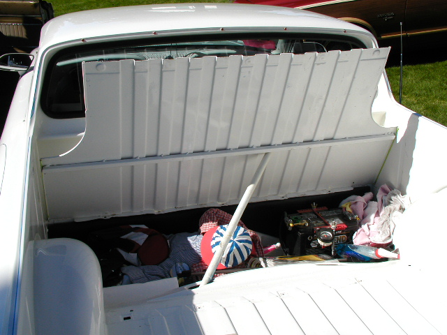 White 1967 Ford Ranchero pickup bed, open, with assorted items including a cooler and blankets