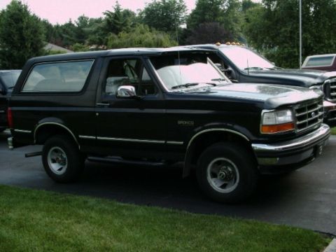 1992 Ford Bronco - A black 1992 Ford Bronco is parked next to another vehicle.
