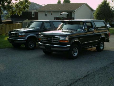 1992 Ford Bronco - Two Ford Broncos are parked side-by-side in a driveway.