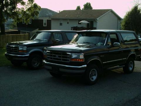1992 Ford Bronco - Two black 1992 Ford Broncos are parked next to each other in a residential driveway.