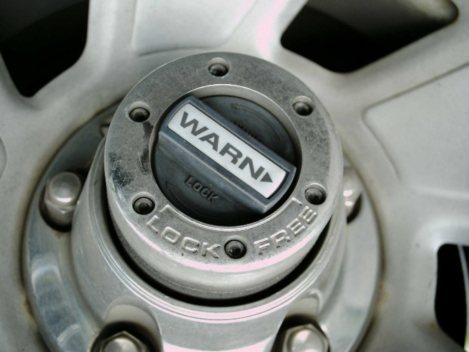 Warn manual locking hub with LOCK and FREE markings on a silver five-spoke wheel