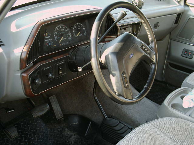 Interior view of a 1988 Ford Bronco with wood trim dashboard and gray seats