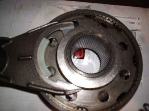 1985 Ford Bronco - Overhead close-up of a transmission synchronizer hub and sliding sleeve with a shift fork engaged in the groove, the fine internal splines…