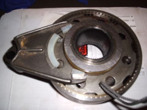 1985 Ford Bronco - A transfer case shift fork with fresh white nylon pads fitted into the sliding clutch sleeve on a splined hub, with the drive chain sprocke…