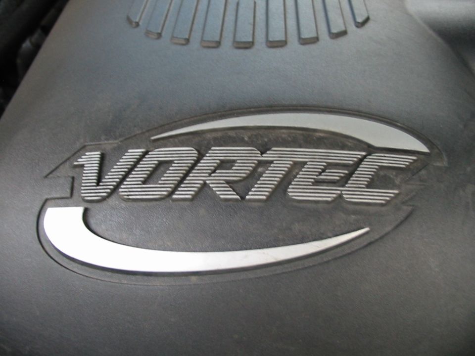 Close-up of the VORTEC logo molded into a black plastic engine cover