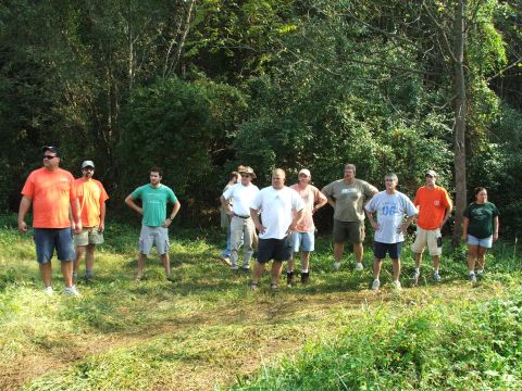1996 Ford Bronco - A group of men are gathered outdoors in a wooded area, posing for a photo.