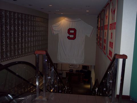 2001 Ford Crown Victoria - A baseball jersey with the number 9 is displayed on a wall above a staircase, with banners on the right wall.