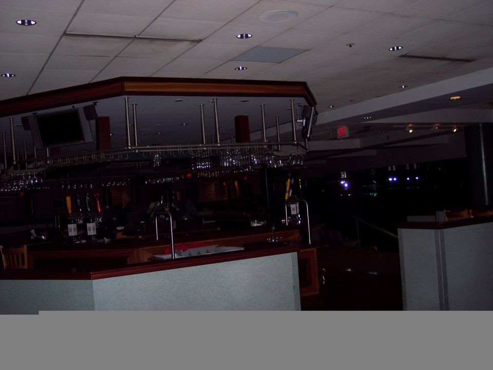 Interior of a bar with mirrored back wall and hanging glasses