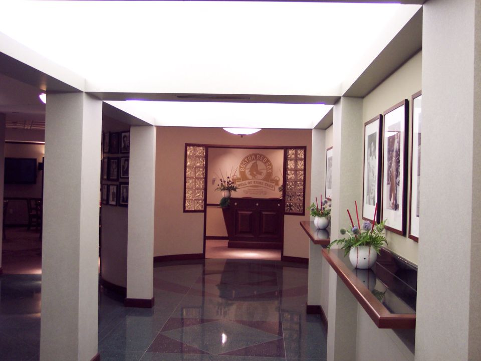 Hall of Fame Club entrance with framed photos on wall and a logo above a cabinet