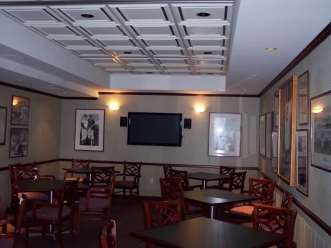 2001 Ford Crown Victoria - A view of a room furnished with tables, chairs, and decorated with framed pictures and a television.