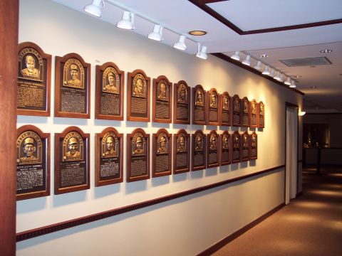 2001 Ford Crown Victoria - A long hallway displays numerous framed plaques, each containing a portrait and biographical text, likely in a museum or hall of fame.