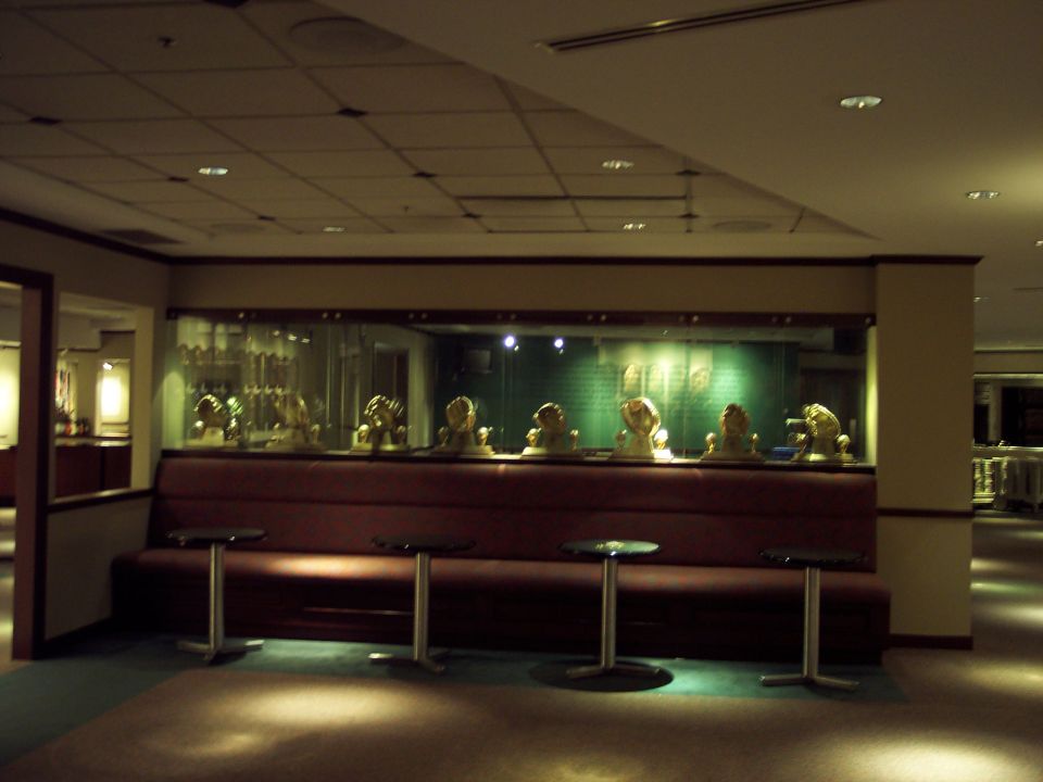 Lounge seating with small tables in front of a display case containing busts