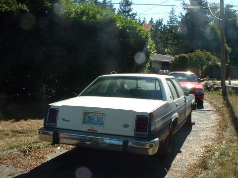 1999 Ford Crown Victoria - This 1980s Ford Crown Victoria is seen from the rear, parked on a driveway with another vehicle behind it.