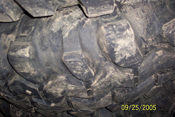 Close-up of a muddy tire tread with visible lug patterns