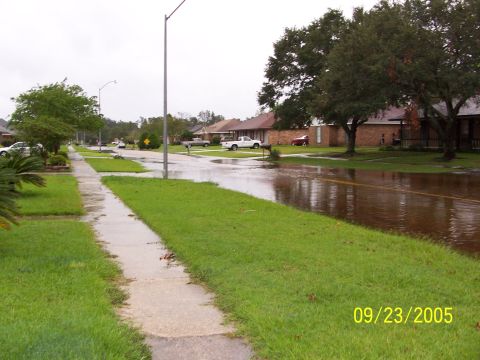 1992 Toyota Hilux - A suburban street is flooded, with water covering the road and lawns. The date 09/23/2005 is visible in the corner.