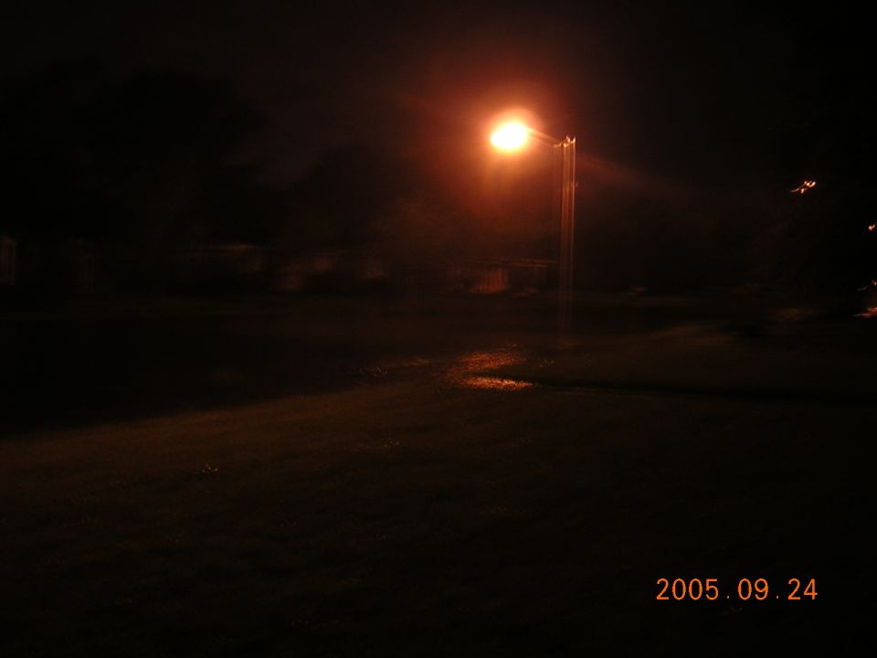 Nighttime street lamp glowing over a dark road, dated 2005.09.24