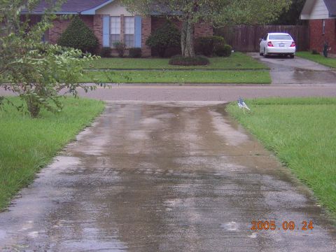 1992 Toyota Hilux - A white sedan is parked in a driveway with wet pavement, suggesting recent rain.