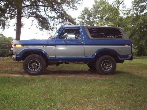 1978 Ford Bronco - Side view of a classic Ford Bronco with a two-tone paint scheme and raised suspension.