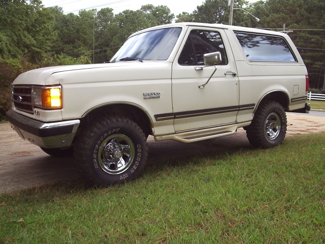 White Ford Bronco with chrome wheels and large tires