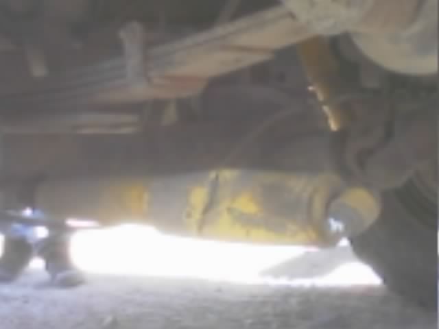 Undercarriage view of a vehicle showing leaf spring and driveshaft