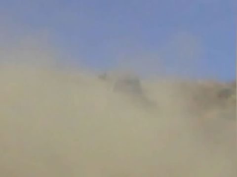 1990 Ford Bronco - blurry image of a dry hillside almost entirely obscured by a thick rising dust cloud.
