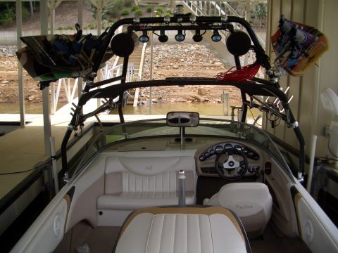 2000 Mastercraft Prostar 190 - The interior of a boat is shown, complete with a wakeboard tower loaded with gear and a dashboard with gauges.