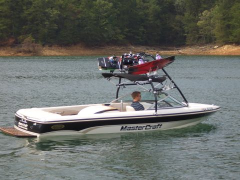 2000 Mastercraft Prostar 190 - Mastercraft boat carrying wakeboards and a driver on a lake.
