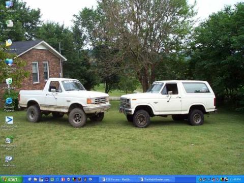 1988 Ford Bronco - A pickup truck and a Bronco are parked side-by-side on a grassy lawn.