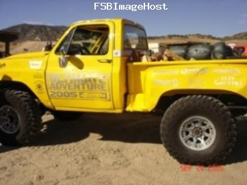1988 Ford Bronco - This yellow pickup truck features "Adventure 2005" text on its door and is seen in a side profile.
