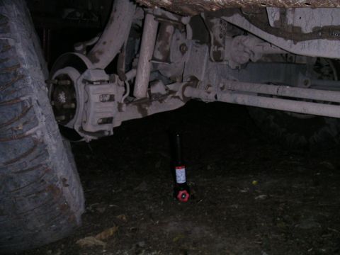 1994 Ford Bronco - The underside of a vehicle is visible, with a tire and a jack placed nearby.