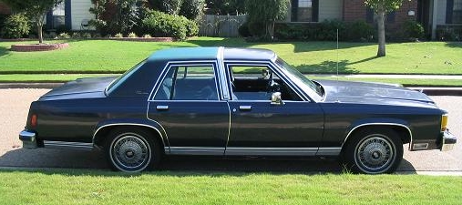 Dark blue 1980s Ford LTD Crown Victoria sedan parked on a grassy lawn