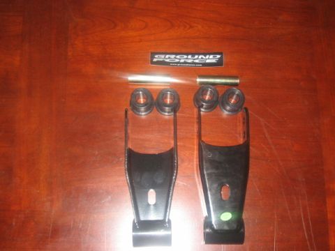 1991 Ford Bronco - Ground Force lift kit components, including shackles and bushings, laid out on a wooden surface.