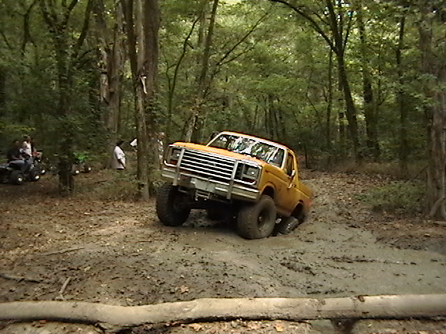 Yellow off-road truck stuck in mud, 1980s grille visible
