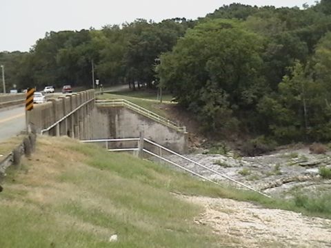 1986 Ford Bronco - Several vehicles are visible on a bridge spanning a rocky, dry creek bed.