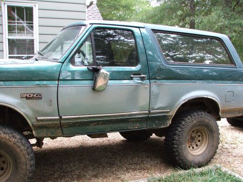 1996 Ford Bronco - This two-tone Ford Bronco shows some wear and tear, including a noticeable dent on the passenger side door.