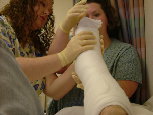 1993 Ford Bronco - Medical professionals apply a cast to a patient's leg in a room with curtains.