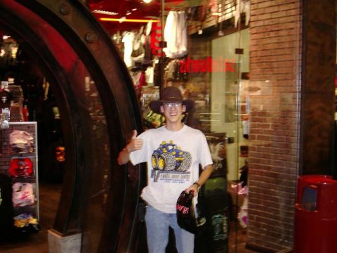 1988 Ford Bronco - A person stands in a store, wearing a hat and a graphic t-shirt, and gives a thumbs-up gesture.