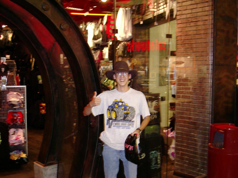 Guy in a store wearing a hat and a t-shirt with a monster truck graphic, giving a thumbs up