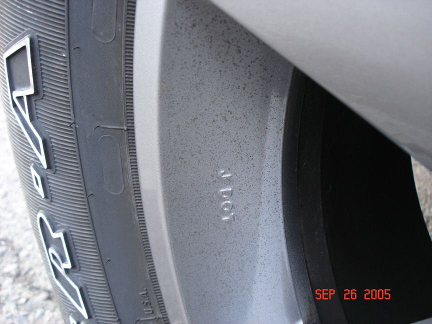 Close-up of silver alloy wheel spoke with 4 DOT casting mark and Goodyear tire sidewall