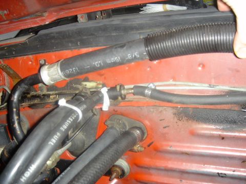 1986 Ford Mustang - Close-up view of engine bay hoses, one labeled 'HIGH PRESSURE FUEL' and another '5/8" 16mm I.D.'.